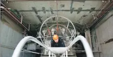  ?? BAI XUEQI / XINHUA ?? A worker inspects power generation facilities at the Vitebsk hydropower station, the largest in Belarus, in April. The $200 million project, built by China National Electric Engineerin­g Co, is part of the Belt and Road Initiative.