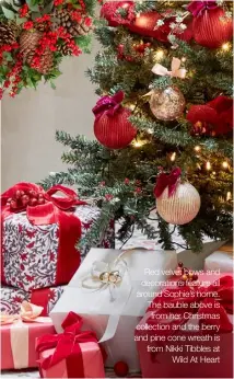  ??  ?? Red velvet bows and decoration­s feature all around Sophie’s home. The bauble above is from her Christmas collection and the berry and pine cone wreath is from Nikki Tibbles at Wild At Heart