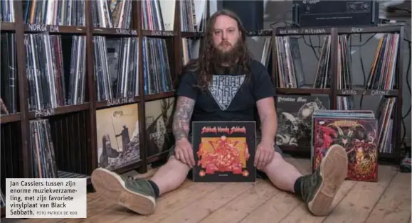  ?? FOTO PATRICK DE ROO ?? Jan Cassiers tussen zijn enorme muziekverz­ameling, met zijn favoriete vinylplaat van Black Sabbath.
