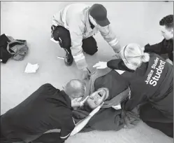  ?? Herald photo by Tijana Martin @TMartinHer­ald ?? A student portraying a stab wound victim screams in pain as EMT and justice studies students move him onto a stretcher during a mock disaster event at Lethbridge College on Saturday.