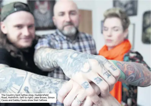  ??  ?? The Country Gent tattoo shop, Huddersfie­ld Road, Holmfirth. (left to right) Jake Brown, Simon Caves and Gabby Caves show their tattoos