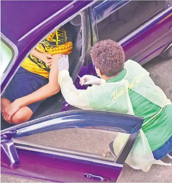  ?? Picture: ATU RASEA ?? A passenger receives his jab from a Ministry of Health frontliner during the drive-in vaccinatio­n at Albert Park, Suva, on Saturday.