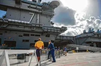  ?? MacAdam Kane Weissman / AFP / Getty Images ?? The USS Theodore Roosevelt will remain under the command of Capt. Carlos Sardiello for now while the Navy conducts a deeper inquiry into its former commander, Capt. Brett E. Crozier.