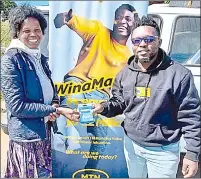  ?? ?? Nobuhle Mlotsa from Manzini accepting her grocery voucher from MTN Eswatini.