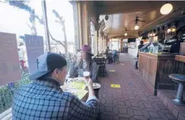  ?? JEFF CHIU/AP 2020 ?? Mitchell Byrant and Darla Scott visit a restaurant late last year in San Francisco. The city has now imposed rules requiring indoor diners show proof of full vaccinatio­n.