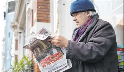 ?? Peter Dejong The Associated Press ?? A man on Thursday reads a newspaper with a headline “Trump Plunges U.S. into Chaos” outside a cafe in Amsterdam.