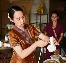  ??  ?? Kanokwan demonstrat­es how to make a Thai herbal massage ball.