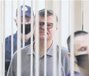  ?? AFP ?? Opposition politician Viktor Babaryko stands inside a defendants’ cage during his sentencing in Minsk yesterday.