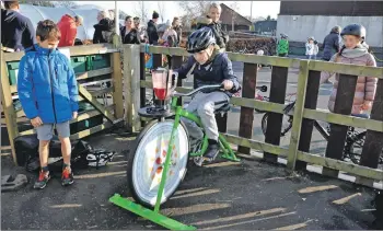  ??  ?? Lewis Gregg tries out his pedalling skills on the fixed bike.