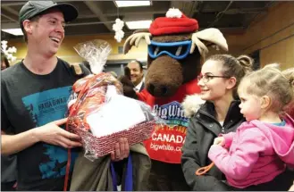  ?? ANDREA PEACOCK/The Okanagan Weekend ?? Joey Hidber, left, was the two-millionth passenger at Kelowna’s airport this year. At right is his wife, Teagan, and their youngest daughter, Mallory, 2.