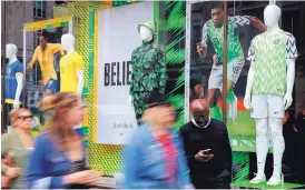  ?? FRANK AUGSTEIN/ ASSOCIATED PRESS ?? The Nigerian, left, and Brazilian national soccer team jerseys are on display at a London shop. The Nigerian design is a nod to eagles — the team’s nickname is Super Eagles — and is a hit.