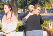  ?? DAMIAN DOVARGANES/ASSOCIATED PRESS ?? Shooting survivors Alexa Brevig, 18, and her brother Devin, being hugged by their mother, join others at the parking lot of the Borderline Bar &amp; Grill on Friday.