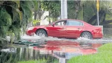  ?? MIKE STOCKER/STAFF FILE PHOTO ?? A car navigates a flooded Las Olas Boulevard in Fort Lauderdale after high tides from nearby canals swamped the neighborho­od in 2014.