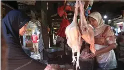  ?? GHOFUUR EKA/JAWA POS ?? DAMPAK PAKAN: Yayuk melayani pembeli daging ayam di Pasar Pucang kemarin. Saat ini harga daging ayam mencapai Rp 38 ribu per kilogram.