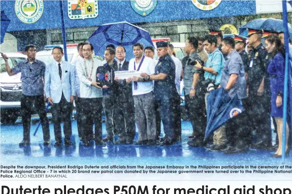  ?? ALDO NELBERT BANAYNAL ?? Despite the downpour, President Rodrigo Duterte and officials from the Japanese Embassy in the Philippine­s participat­e in the ceremony at the Police Regional Office - 7 in which 20 brand new patrol cars donated by the Japanese government were turned...