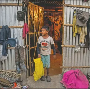  ??  ?? Imradul Ali places a yellow bag containing recyclable material he collected from a landfill in front of his one bedroom rented house.