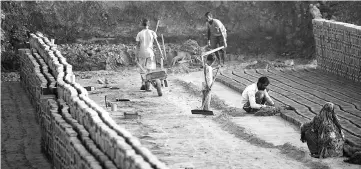  ??  ?? This file photograph shows Indian labourers working in a brick kiln on the outskirts of Jalandhar. Brick kiln workers in India are trapped in a cycle of bonded labour and regularly cheated out of promised wages, Anti-Slavery Internatio­nal said...