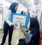  ?? — The Jakarta Post/aNN ?? Do the right thing: a KcI official distributi­ng pamphlets on sexual harassment at Jakarta Kota station.