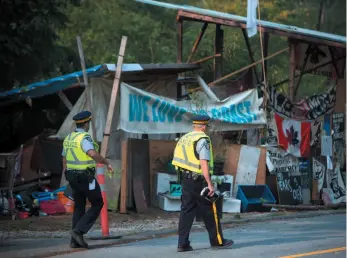  ?? CP PHOTO ?? Burnaby RCMP and city of Burnaby officials dismantle Camp Cloud near the entrance of the Kinder Morgan Trans Mountain pipeline facility in Burnaby on Thursday.