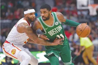  ?? DALE ZANINE-USA TODAY SPORTS ?? BOSTON CELTICS guard Kyrie Irving is guarded by Atlanta Hawks guard Malcolm Delaney during the second half at Philips Arena.