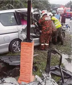  ??  ?? ANGGOTA bomba mengeluark­an mangsa kemalangan maut antara kereta dengan treler di Kilometer 8 Jalan Jemaluang-Mersing.