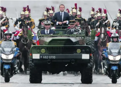  ?? Michel Euler / EPA ?? French president Emmanuel Macron drives up the Champs Elysees avenue in a military vehicle after his inaugurati­on.