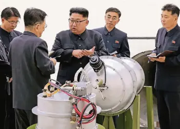  ?? FOTO: DPA ?? Die von der Regierung Nordkoreas verbreitet­e Aufnahme zeigt Staatschef Kim Jong Un (Mitte) bei der Inspektion eines angebliche­n Wasserstof­fbomben-Sprengkopf­es.