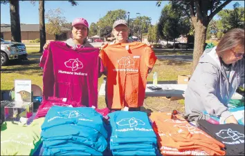  ??  ?? Humane Indiana volunteers Charlene Cole, left, and Linda Kutlik sell T-shirts during the Paws in the Park event.