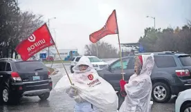  ?? [EDUARDO LIMA/THE CANADIAN PRESS VIA AP] ?? Members of Unifor, the union representi­ng the workers of Oshawa’s General Motors assembly plant, stand near the entrance to the plant Monday in Oshawa, Ontario, Canada. GM will lay off thousands of factory and white-collar workers in North America and put five plants up for possible closure as it restructur­es to cut costs. GM is closing the Oshawa plant.