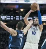  ?? CHRIS SZAGOLA — THE ASSOCIATED PRESS ?? The 76ers’ Marco Belinelli, right, shoots a 3-pointer as the Mavericks’ Dwight Powell, left, defends during the second half Sunday in Philadelph­ia. The 76ers won 109-97.