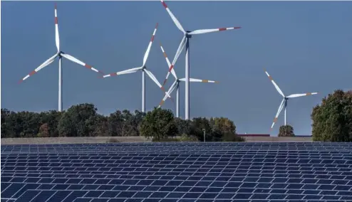  ?? ?? Wind turbines turn behind a solar farm in Rapshagen, Germany.