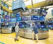  ??  ?? Traders on the floor of the partially reopened New York Stock Exchange on Friday. The U.S. Congressio­nal Budget Office predicts 21.5 per cent growth in the U.S. economy in 2020’s third quarter.