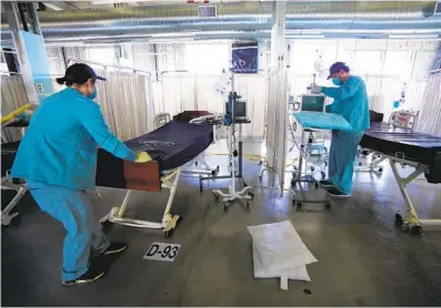  ?? NELVIN C. CEPEDA U-T ?? At Palomar Medical Center Escondido on Tuesday, Joseph Krivolapov (right), and his brother John, both from the hospital’s environmen­tal ser vices department, disinfect beds that will be in a COVID-19 unit.