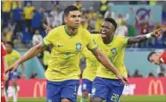  ?? ?? Brazil’s Casemiro (L) celebrates with teammate Vinicius Junior after scoring his team’s goal against Switzerlan­d at Stadium 974 yesterday.