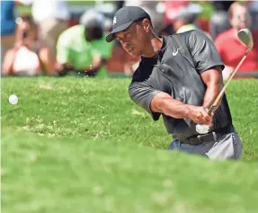  ?? JOHN DAVID MERCER/USA TODAY SPORTS ?? Tiger Woods blasts out of the sand onto the chipping green Wednesday. He’ll play his first Tour Championsh­ip since 2013.