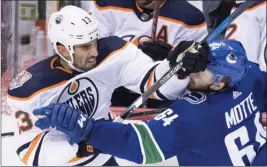  ?? The Canadian Press ?? Vancouver Canucks forward Tyler Motte, right, roughs it up with Edmonton Oilers defenceman Jason Garrison during NHL preseason action in Vancouver on Tuesday.