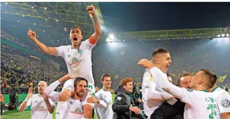  ?? FOTO: THISSEN/DPA ?? Die Bremer bejubeln ausgelasse­n ihren Pokal-Coup, und Martin Harnik trägt seinen Kapitän Max Kruse auf den Schultern.