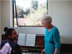  ??  ?? Deirdre Larkin looks on as she teaches piano to Vuyo Tshwele (16) at St Peters College in Johannesbu­rg.