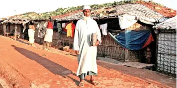  ?? — Reuters photo ?? Hussein Ahmed poses for a picture while holding his documents of the land purchased in Myanmar at the Kutupalong camp in Cox’s Bazar, Bangladesh.