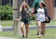  ?? AP Photo/David J. Phillip ?? A student, left, reacts after retrieving her belongings inside Santa Fe, Texas, High School on Saturday.   