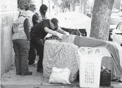  ?? GODOFREDO A. VÁSQUEZ AP FILE ?? Members of the San Francisco Homeless Outreach Team speak with people camped on a sidewalk.