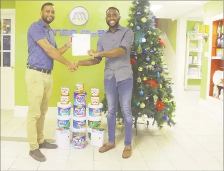  ??  ?? Isaac Bunbury (right) receiving his cheque for the grand prize of $500,000 from ANSA McAl Trading’s Constructi­on Solutions Manager, Andre Ally.