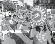  ?? PAUL SANCYA/AP ?? United Auto Workers members walk in the Labor Day parade in Detroit.