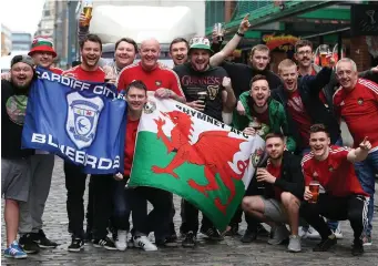  ??  ?? Wales supporters gather in Dublin city centre ahead of the game in The Aviva Stadium tonight. Below: Sharon Edwards and Paul Jones are all set for the big game. Pics: Damien Eagers