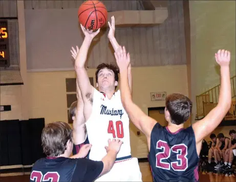  ?? RICK PECK/SPECIAL TO MCDONALD COUNTY PRESS ?? McDonald County’s Bucky Harrell shoots amid a trio of Life Way Christian Warriors during the Mustangs’ 59-29 win on Jan. 20 in the Tri-State Basketball Classic in Jay, Okla.