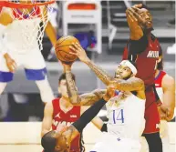  ?? MICHAEL REAVES / GETTY IMAGES ?? Brandon Ingram of the New Orleans Pelicans goes up for a layup Friday against Bam Adebayo of the Miami Heat.