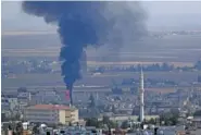  ?? AP PHOTO/LEFTERIS PITARAKIS ?? Smoke billows from a fire in Ras al-Ayn, Syria, on Friday.