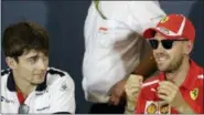  ?? CLAUDE PARIS — THE ASSOCIATED PRESS ?? In this file photo, Ferrari driver Sebastian Vettel of Germany, right, is flanked by Sauber driver Charles Leclerc of Monaco during a news conference, at the Monaco racetrack, in Monaco. Kimi Raikkonen is leaving Ferrari for Sauber and will be replaced by rookie Charles Leclerc, that will team up with Sebastian Vettel.