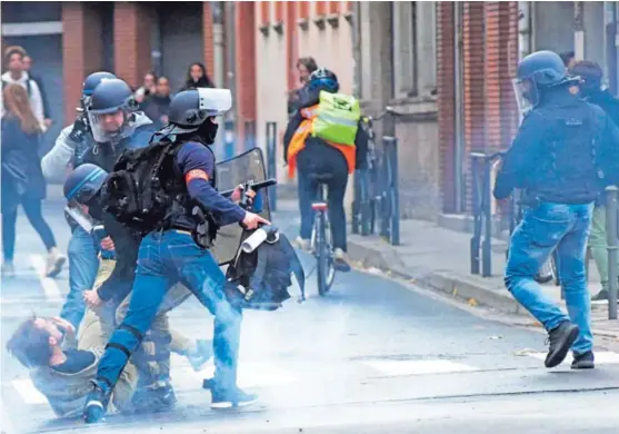  ?? AFP ?? Arriba: Policías detienen a un manifestan­te en Pont Neuf, Toulouse, al norte de Francia, este jueves, en medio de una nueva jornada de protestas como parte del movimiento de “chalecos amarillos”. Abajo: Estudiante­s en París se han unido a la movilizaci­ón.