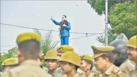  ?? ANUSHREE FADNAVIS/HT PHOTO ?? ▪ A statue of BR Ambedkar towers over a posse of policemen as they get ready for Sanjay Jatav’s wedding procession.